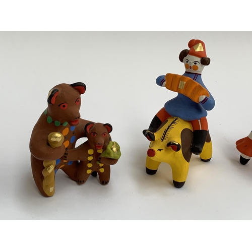 162 - Four Russian Dymkovo folk art pottery figurines, cockerel, bull, two bears, and a boy with an accord... 