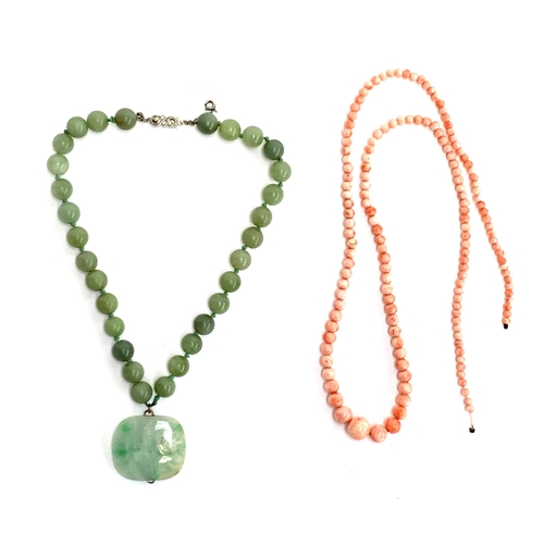 5 - A jade bead necklace, the 30 beads each approx. 1.1cm, suspending a large jade pendant with yellow m... 