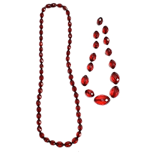 23 - A cherry bakelite faceted bead necklace, 58cmL unclasped length, together with a small quantity of l... 