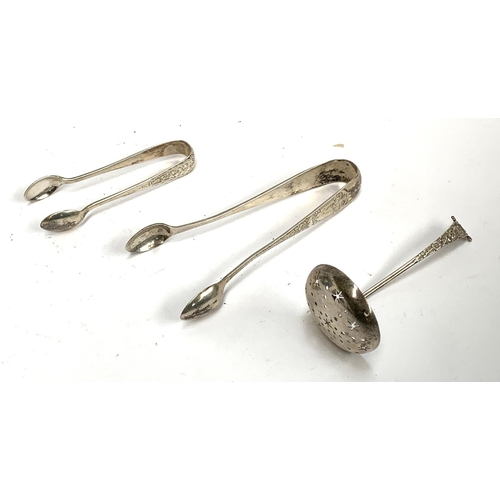 106 - Two sets of silver sugar tongs, together with a sugar sifter, gross weight 61.7g