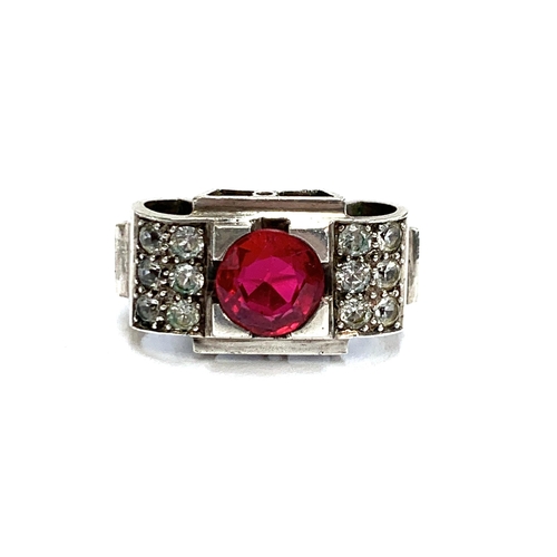 34 - A substantial European 1920s Art Deco silver tank ring set with a central synthetic ruby and paste, ... 