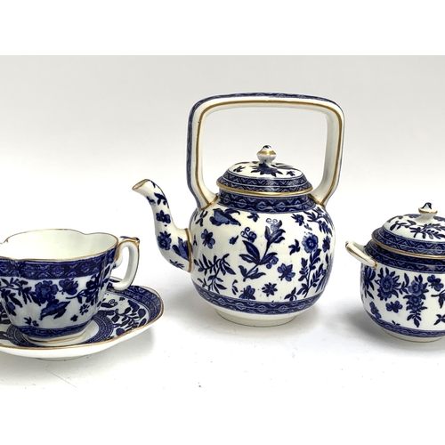 212 - A blue and white porcelain tea set, heightened in gilt, comprising teapot, teacups, saucers, milk ju... 