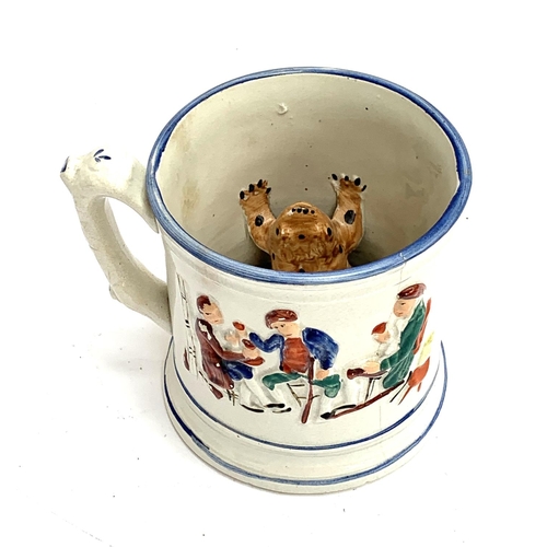 217 - A Staffordshire frog mug (af), painted with tavern scenes in relief, the inside with a model of a fr... 