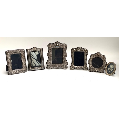 102 - Five chased and reppousse silver picture frames, the largest 23x18.5cm externally, together with a f... 