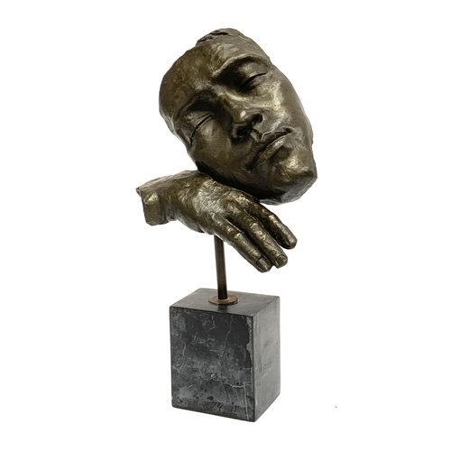 312 - A bronze abstract sculpture of a mask leaning on a hand, on plinth, 46cmH