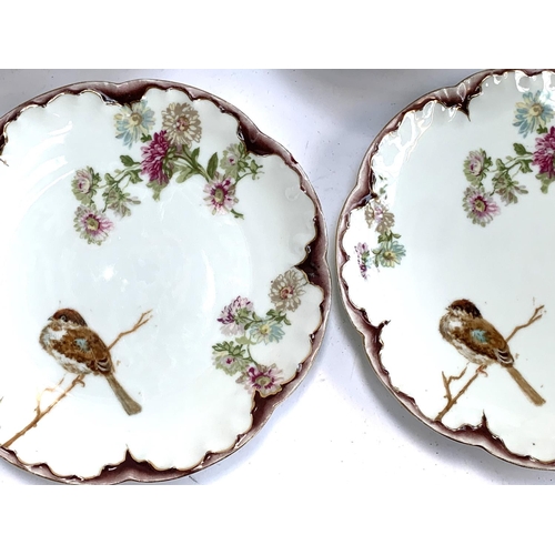 321 - A quantity of Limoges plates and tazza dishes with hand painted birds, marked to reverse Limoges A. ... 