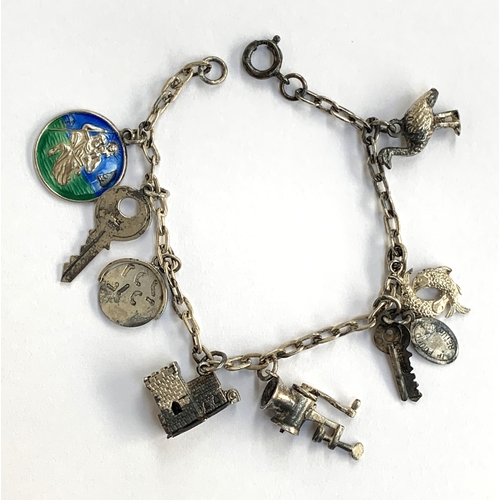 49 - A silver charm bracelet with a variety of charms including enamel St.Christopher, spinning charm, ke... 