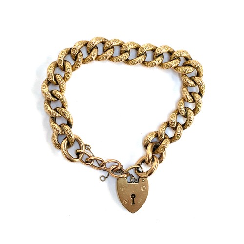A 9ct gold curb link bracelet with heart padlock, the links with floral chasing, gross weight 20.6g