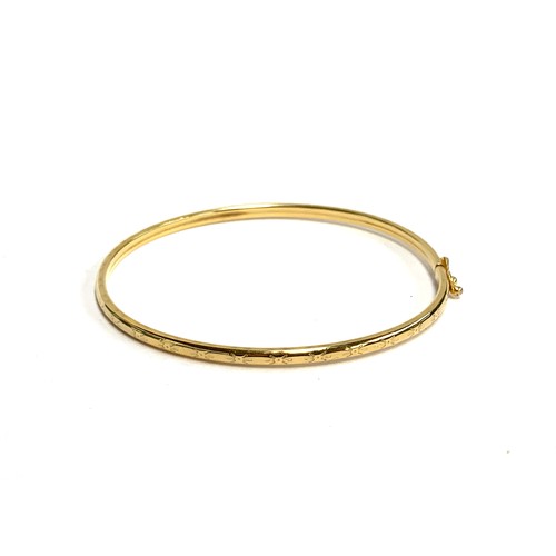 47 - A 9ct gold bangle with engraved star detail, 6.4cmW, 3.1g