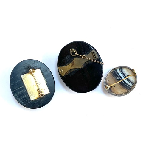 4 - A Victorian carved jet cameo brooch, 5cmL, pin absent; together with two banded agate cabochon brooc... 