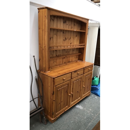 811 - A pine dresser, the base with three drawers over three cupboard doors, the top with three shelves, 1... 