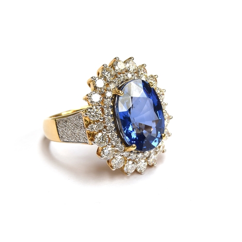 31 - An 18ct gold sapphire and diamond cluster ring, the large Sri Lankan sapphire 14x10mm weighing appro... 