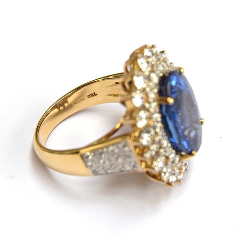 31 - An 18ct gold sapphire and diamond cluster ring, the large Sri Lankan sapphire 14x10mm weighing appro... 