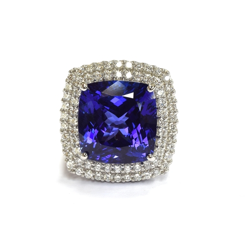 35 - A platinum mounted tanzanite and diamond cluster ring, the large cushion cut tanzanite measuring app... 