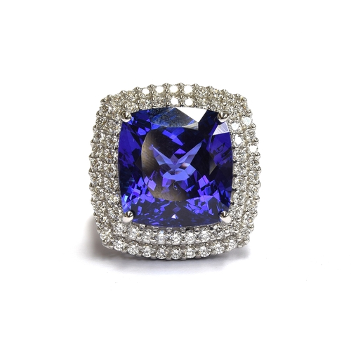 35 - A platinum mounted tanzanite and diamond cluster ring, the large cushion cut tanzanite measuring app... 