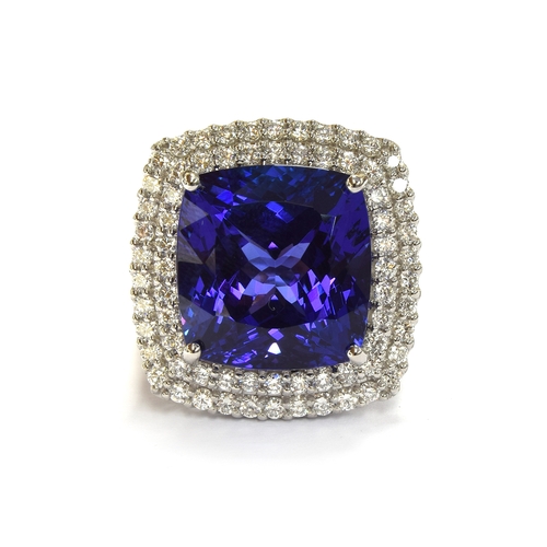 35 - A platinum mounted tanzanite and diamond cluster ring, the large cushion cut tanzanite measuring app... 