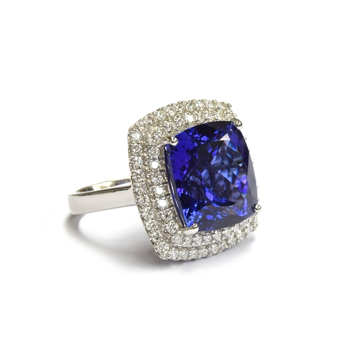 35 - A platinum mounted tanzanite and diamond cluster ring, the large cushion cut tanzanite measuring app... 