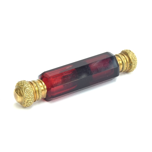 231 - A ruby glass double ended scent bottle, each end with chased gilt metal hinged caps, 12.4cm long