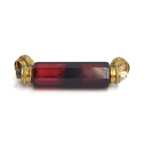 231 - A ruby glass double ended scent bottle, each end with chased gilt metal hinged caps, 12.4cm long