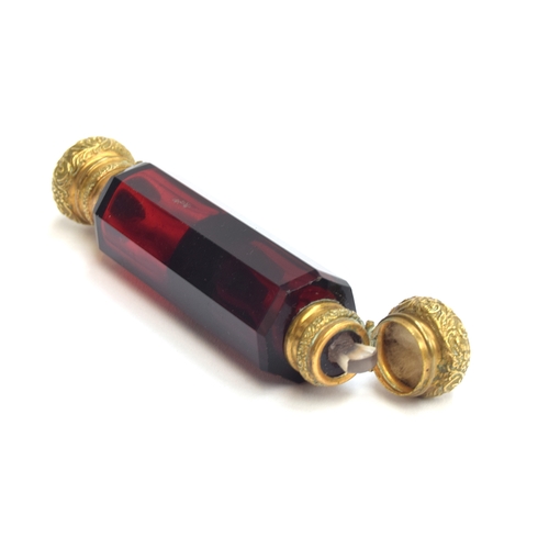 231 - A ruby glass double ended scent bottle, each end with chased gilt metal hinged caps, 12.4cm long