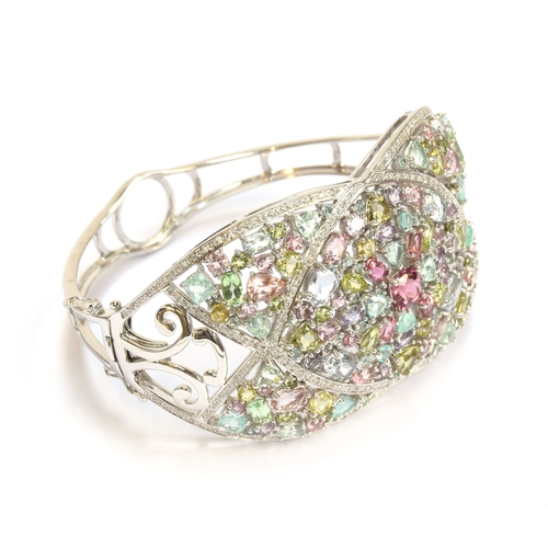 90 - A heavy 18ct white gold, tourmaline and diamond bangle, set with a total of 25.2cts of stones includ... 