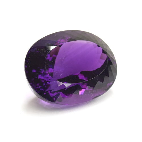 112 - A large unmounted Lusaka Amethyst, the oval faceted stone weighing 168.6cts, measuring 40x32mm, purc... 