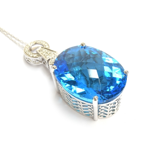 88 - An 18ct white gold mounted Swiss blue topaz and diamond pendant, the topaz weighing 62.7cts and meas... 