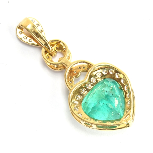 43 - An 18ct gold emerald and diamond pendant, the large heart cut Colombian emerald weighing 10.8cts and... 