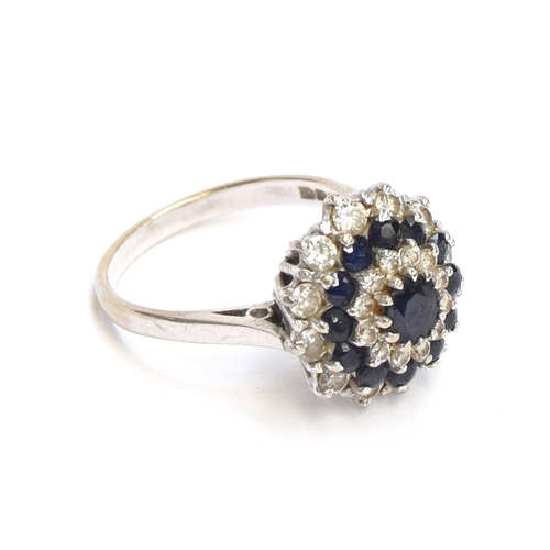 19 - An 18ct white gold, sapphire and diamond cluster ring, the ring head 1.5cm diameter, size M, 5.4g