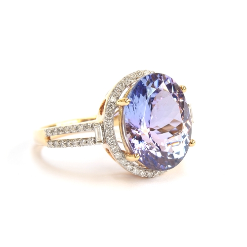 109 - An 18ct gold ring set with a pink tanzanite and diamonds, the oval cut tanzanite 6.1cts and 13.2x10.... 