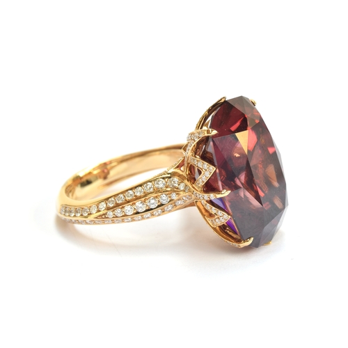 122 - A Kat Florence 18ct gold, red zircon and diamond ring, the natural red zircon 30.7cts and 20x4x14.3m... 