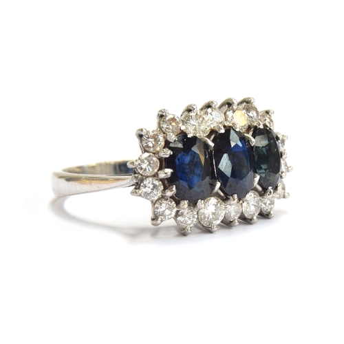 20 - An 18ct white gold mounted sapphire and diamond triple cluster ring, the diamonds totalling approx. ... 