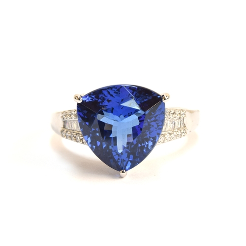 104 - A platinum, tanzanite and diamond ring, the trillion cut tanzanite 7.5cts and 12mm wide, diamonds to... 