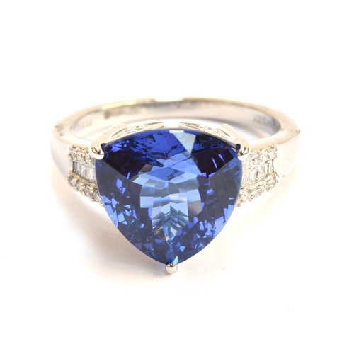 104 - A platinum, tanzanite and diamond ring, the trillion cut tanzanite 7.5cts and 12mm wide, diamonds to... 