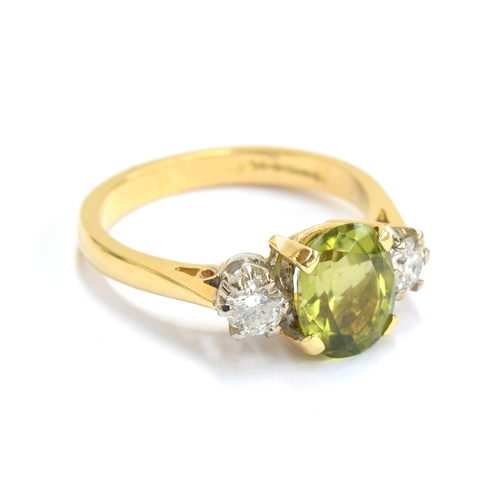 24 - An 18ct gold, peridot and diamond three stone ring, the oval cut peridot approx. 1.7cts, size M 1/2,... 