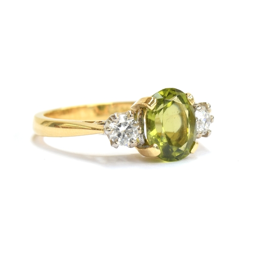 24 - An 18ct gold, peridot and diamond three stone ring, the oval cut peridot approx. 1.7cts, size M 1/2,... 