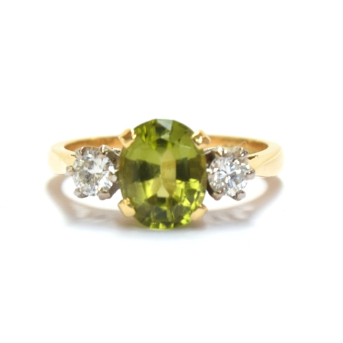 24 - An 18ct gold, peridot and diamond three stone ring, the oval cut peridot approx. 1.7cts, size M 1/2,... 