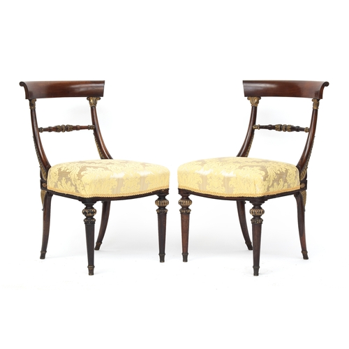 446 - A set of four rosewood and parcel gilt Regency side chairs, the curved rail on gilt anthemion capped... 