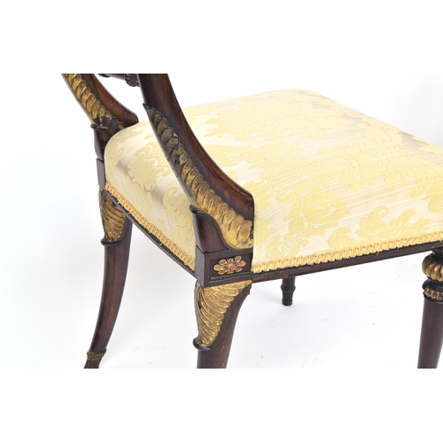 446 - A set of four rosewood and parcel gilt Regency side chairs, the curved rail on gilt anthemion capped... 