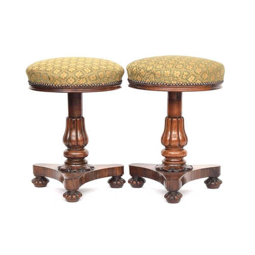 404 - A pair of late Regency rosewood piano stools, each on column support and triform base, 35cm diameter... 