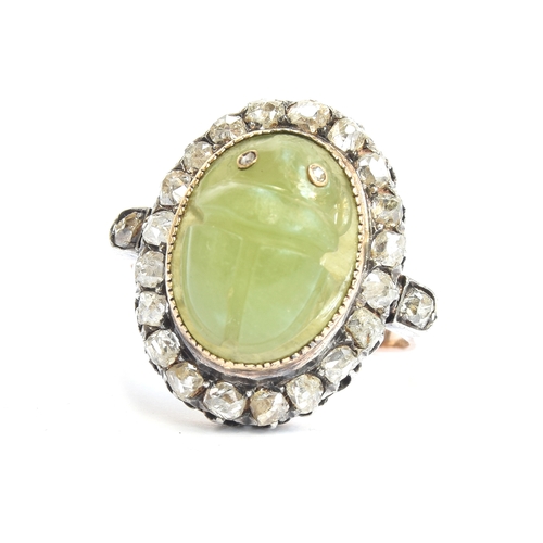 6 - A late Victorian Egyptian Revival carved jade scarab and diamond cluster ring, the carved green jade... 