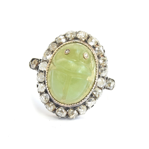 6 - A late Victorian Egyptian Revival carved jade scarab and diamond cluster ring, the carved green jade... 