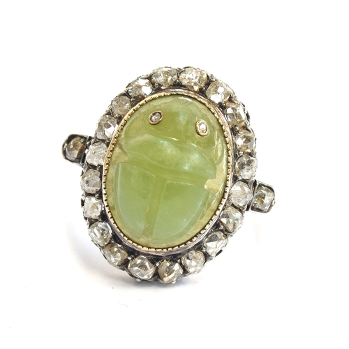 6 - A late Victorian Egyptian Revival carved jade scarab and diamond cluster ring, the carved green jade... 