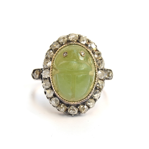 6 - A late Victorian Egyptian Revival carved jade scarab and diamond cluster ring, the carved green jade... 