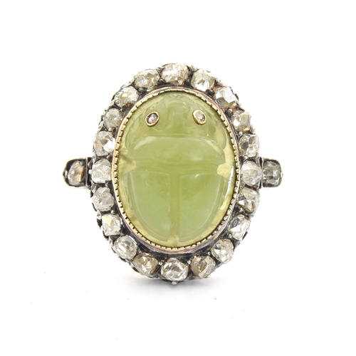 6 - A late Victorian Egyptian Revival carved jade scarab and diamond cluster ring, the carved green jade... 