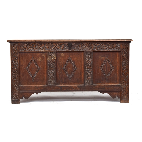 364 - An 18th century three panel oak coffer, with lozenge carving, the styles carved with stylised grape ... 