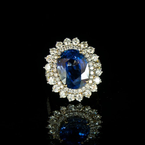 31 - An 18ct gold sapphire and diamond cluster ring, the large Sri Lankan sapphire 14x10mm weighing appro... 