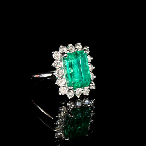 32 - A platinum mounted emerald and diamond cluster ring, the Boyaca Columbian emerald weighing 5.75cts a... 