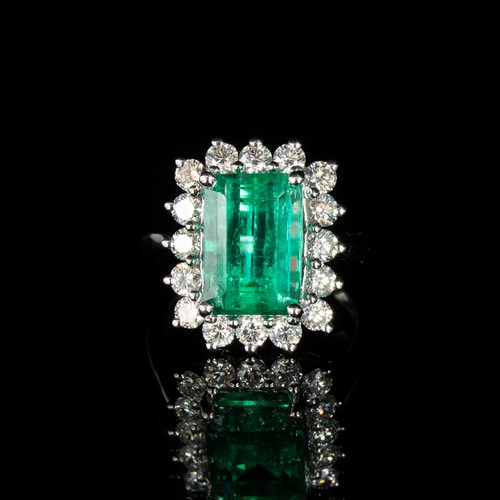 32 - A platinum mounted emerald and diamond cluster ring, the Boyaca Columbian emerald weighing 5.75cts a... 