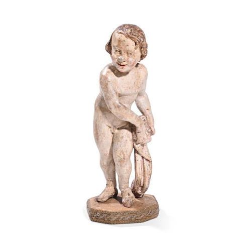 235 - An 18th century carved white painted figure of a child, possibly Spanish, modelled nude and holding ... 